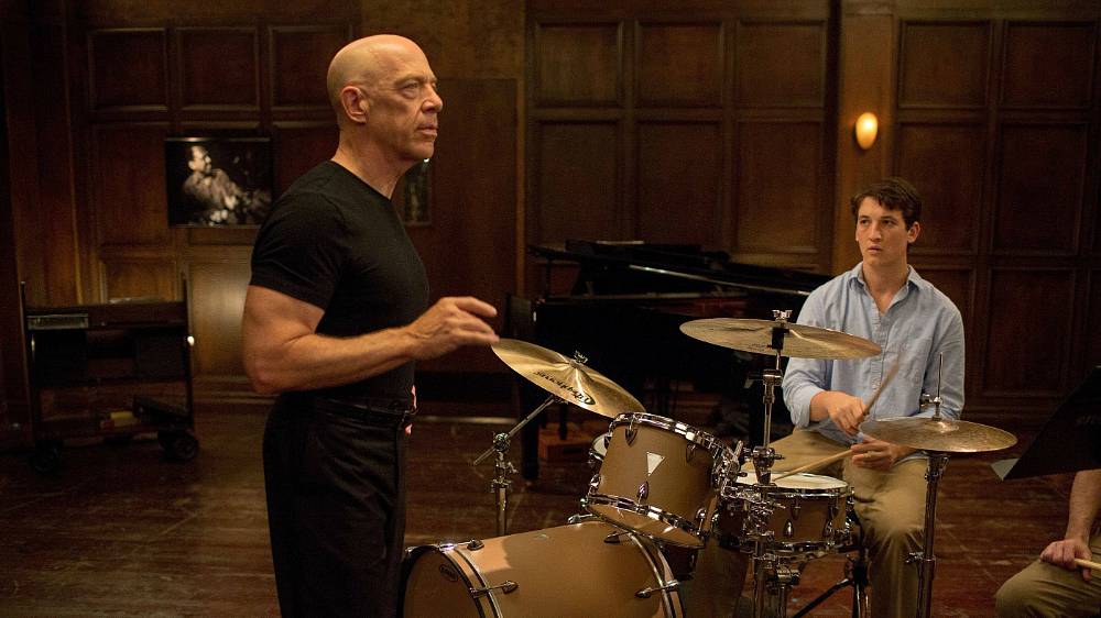 Whiplash (2014), Andrew Neiman je devatenáctiletý jazzový bubeník, který sní o slávě, ale není si jistý tím, zda se jeho sny někdy naplní. Pronásledovaný neúspěšnou spisovatelskou kariérou svého otce je rozhodnutý vystoupat až na samotný vrchol nejprestižnější hudební konzervatoře. Jednoho večera na Andrewa, který právě cvičí na bicí, narazí Terence Fletcher, dirigent, proslavený svým učitelským talentem ve stejné míře jako svými nemilosrdnými praktikami. Ačkoliv si spolu toho večera příliš mnoho nesdělí, probudí Fletcher v Andrewovi touhu dosáhnout svého cíle. K Andrewovu překvapení dalšího dne Fletcher požádá o to, aby byl Andrew přidělen k jeho kapele. Tento jediný čin mladíkovi navždy změní život. Zpočátku je Andrew nucen fungovat pouze jako „záskok" a otáčet partituru hlavnímu bubeníkovi. Ale na příští soutěži, které se kapela účastní, hlavní bubeník řízením osudu či něčím přičiněním ztratí svou partituru. Andrew, který zná celý part nazpaměť, dostane šanci hrát.